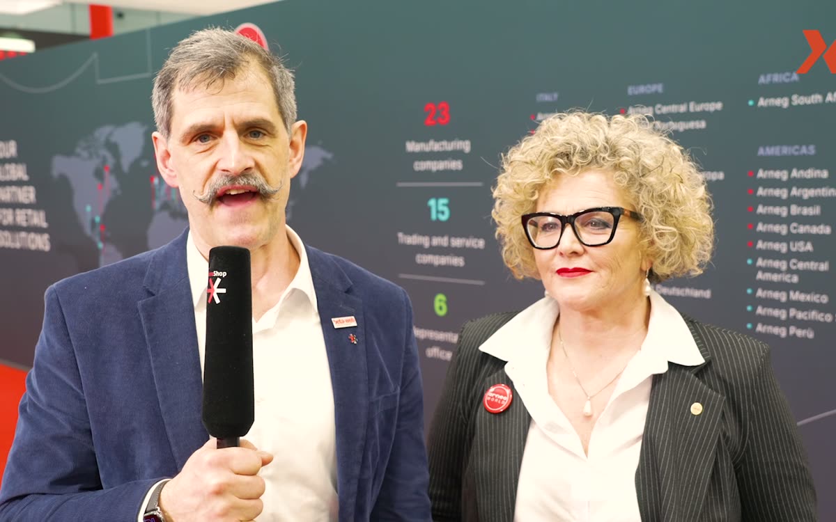 iXtenso reporter with microphone interviewing at a booth